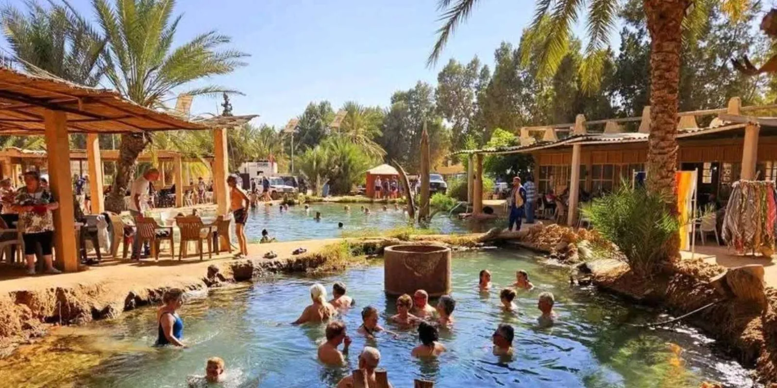 Visitors bathing in the warm spring pool at Ksar Ghilane