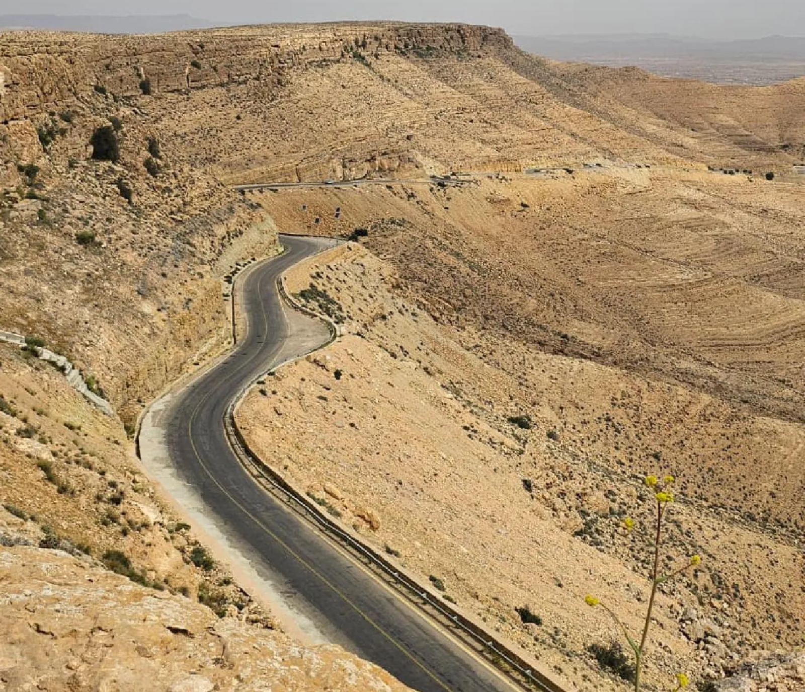 The road folding down through the Dahar plateau toward the desert