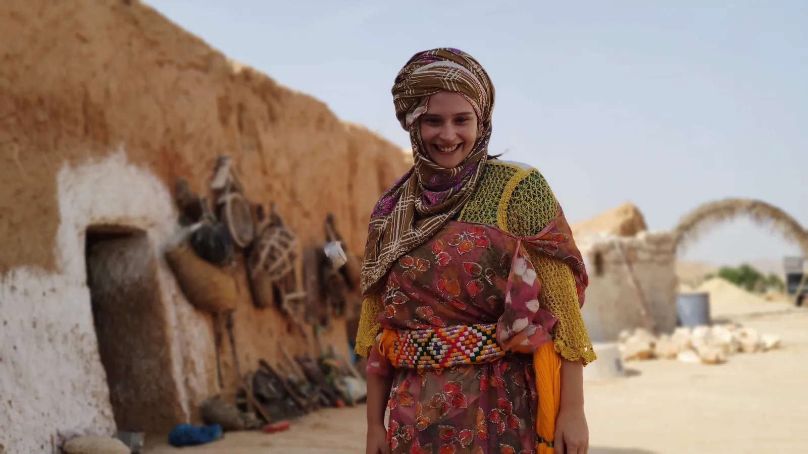 A Berber woman in traditional dress outside a troglodyte house at Matmata