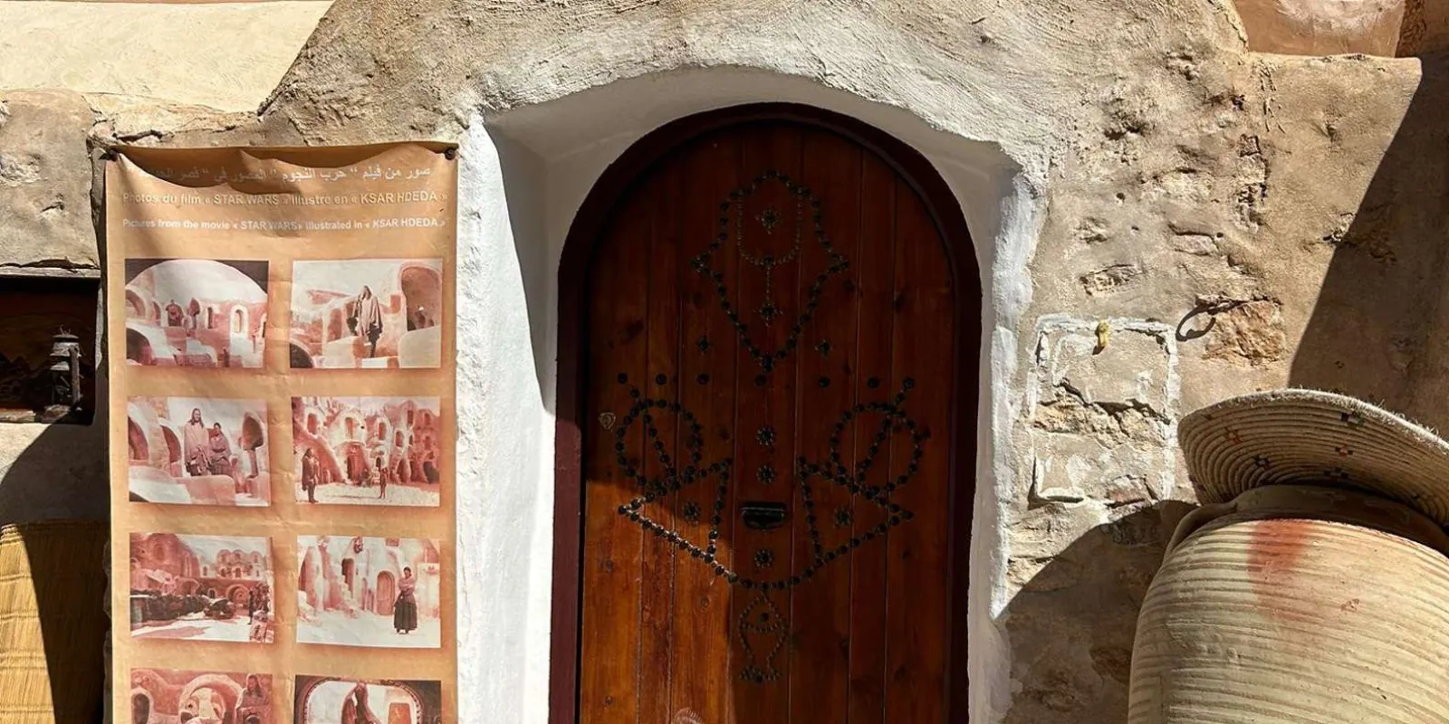 A carved door at Sidi Driss beside photographs of the Star Wars shoot